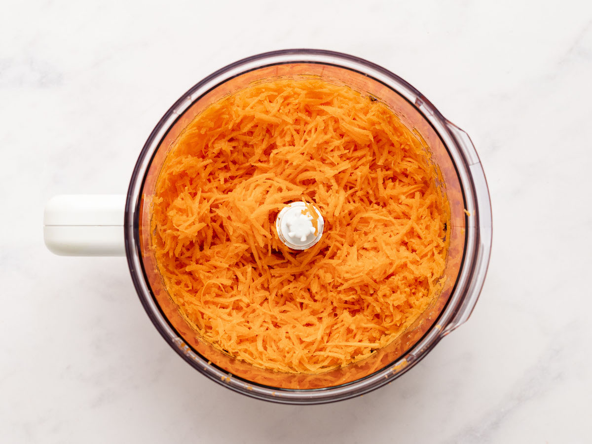 shredded carrots in bowl of food processor.