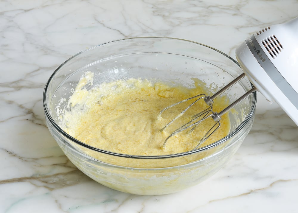 Electric mixer in a bowl of partially made banana bread batter.
