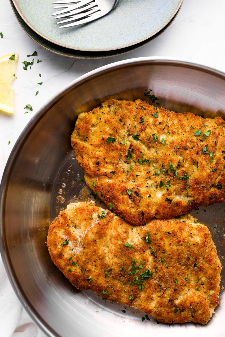 Parmesan crusted chicken in a skillet.
