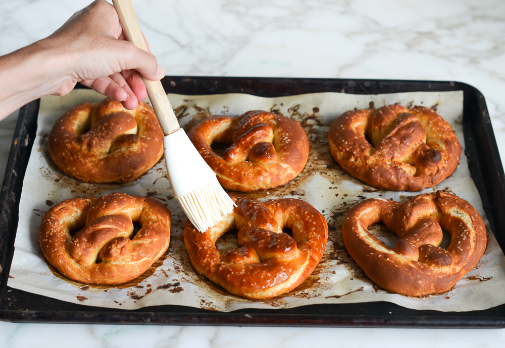 brushing baked soft pretzels with butter