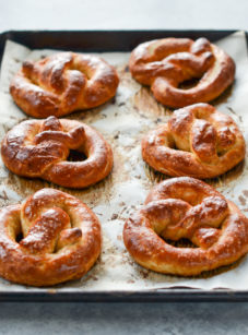 Soft pretzels on a lined baking sheet.