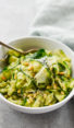 Bowl of zucchini noodles with pesto and pine nuts.