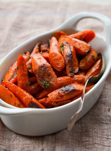 Roasted carrots with thyme in a baking dish.