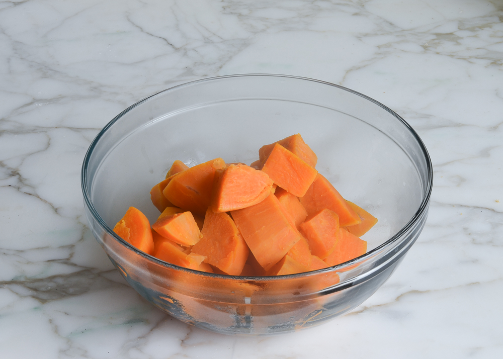 Pieces of cooked sweet potato in a glass bowl.