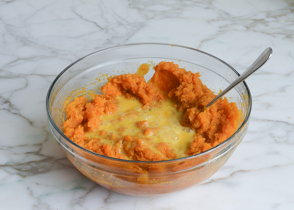 Eggs in a bowl with mashed sweet potatoes.