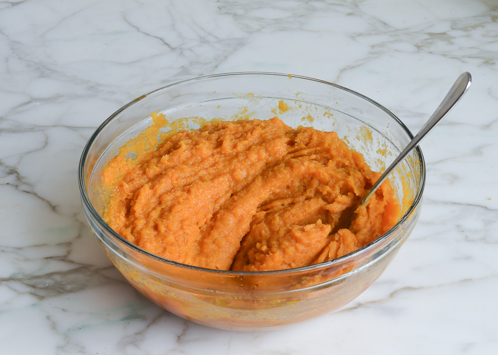 Fork in a bowl of sweet potato mixture.