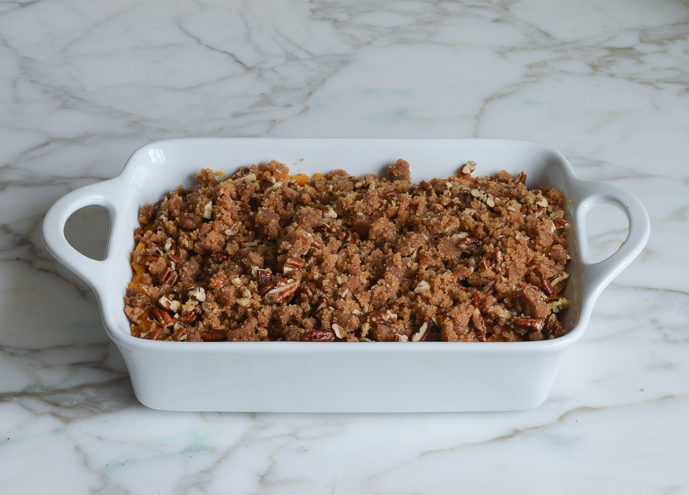 Streusel topping on mashed sweet potatoes in a casserole dish.