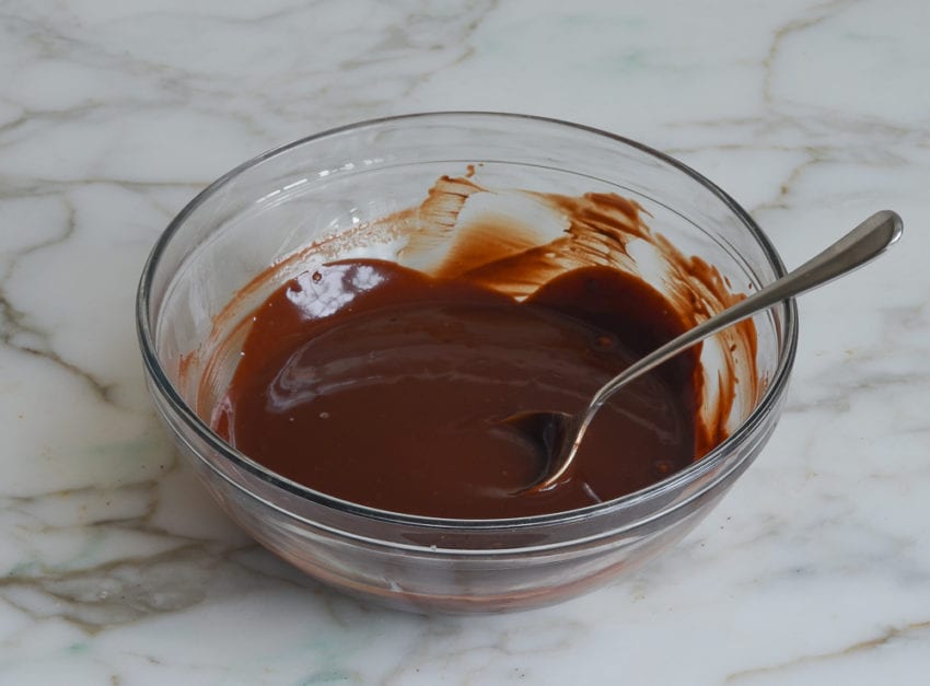 Spoon in a bowl of melted chocolate.