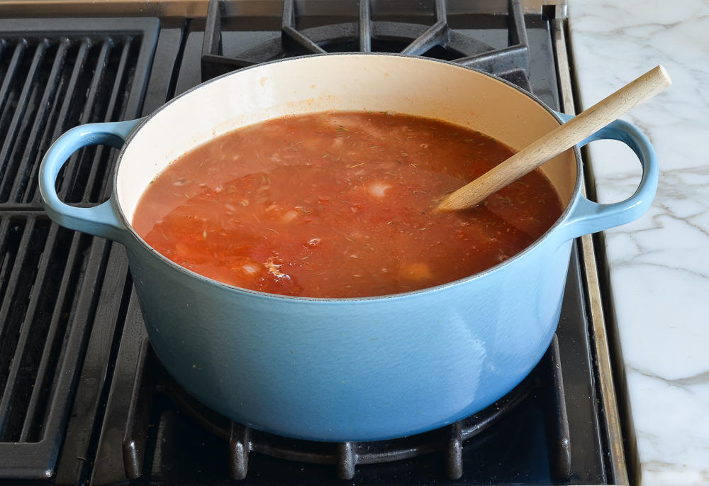 tomatoes and broth added to the pot.