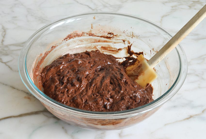 Spatula in a bowl of chocolate muffin batter.