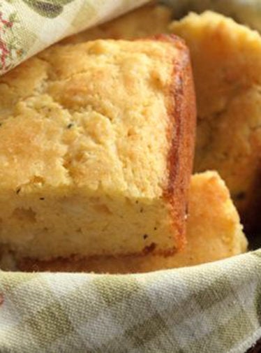 Pieces of savory cornbread with cheddar and thyme in a basket.