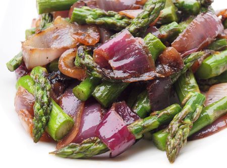 Plate of grilled asparagus and red onions with olive oil and balsamic vinegar.