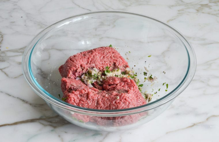 Ground meat in a bowl with seasonings.