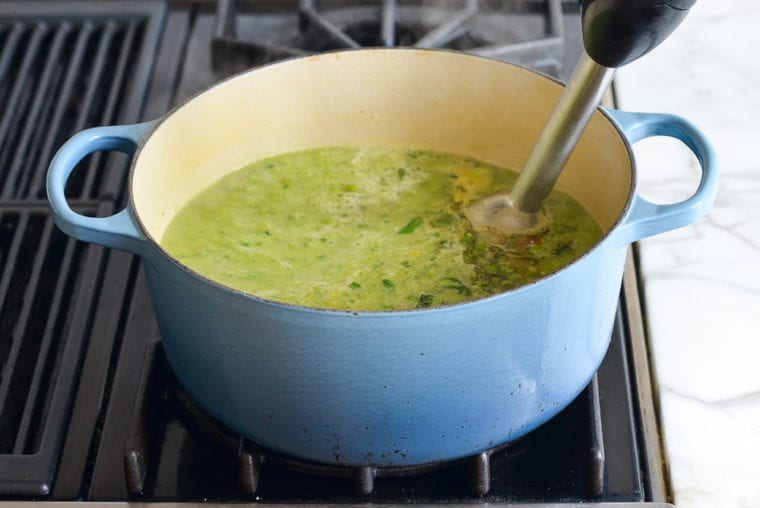 pureeing the pea soup with a stick blender