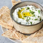 Tzatziki in a bowl with pitas.