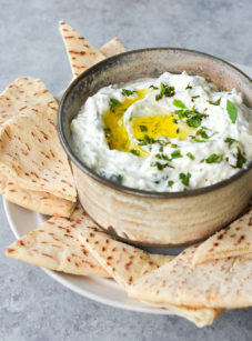 Tzatziki in a bowl with pitas.