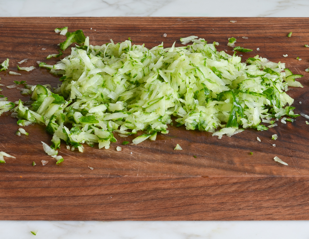 shredded zucchini on cutting board