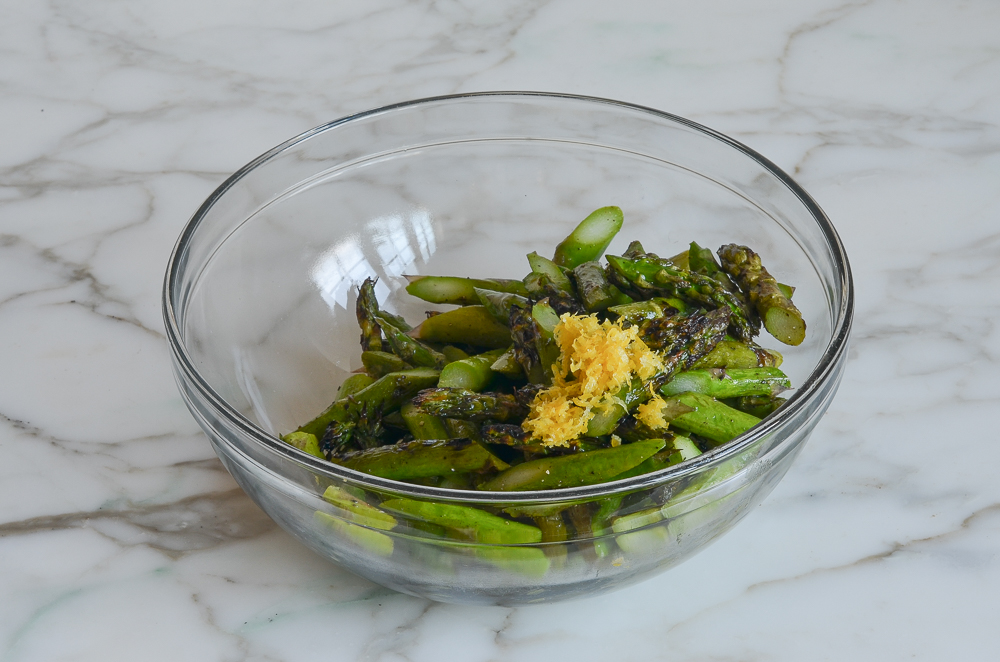 grilled asparagus in mixing bowl with lemon