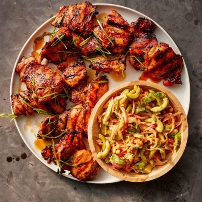 asian bbq chicken on platter with cucumber salad