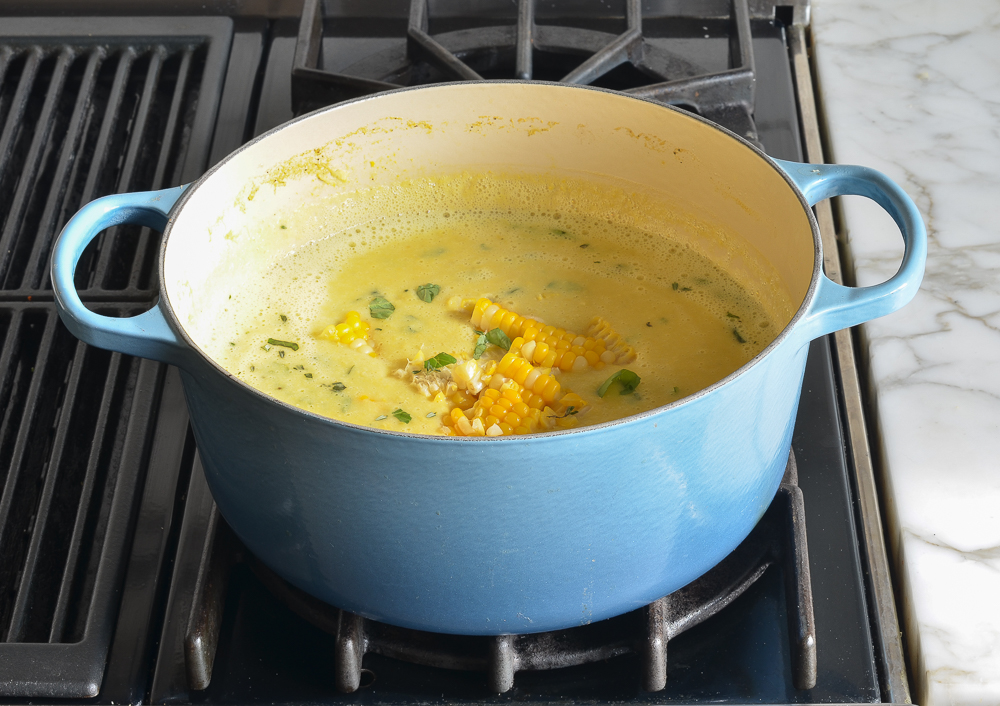 Corn kernels in a Dutch oven of soup.