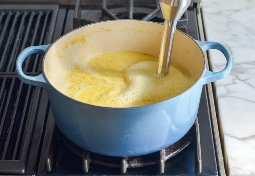 Immersion blender in a Dutch oven of soup.