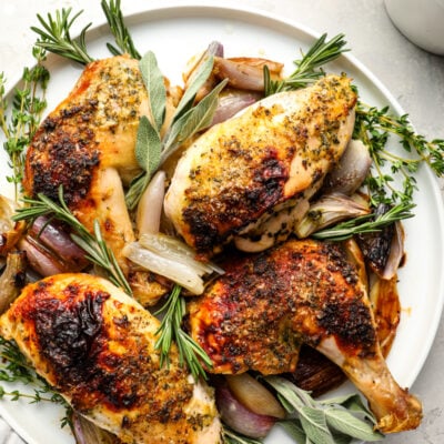 Roast chicken with herb butter on platter.
