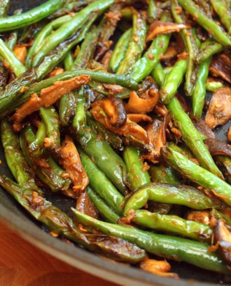 Skillet of stir-fried Szechuan green beans and shiitake mushrooms.