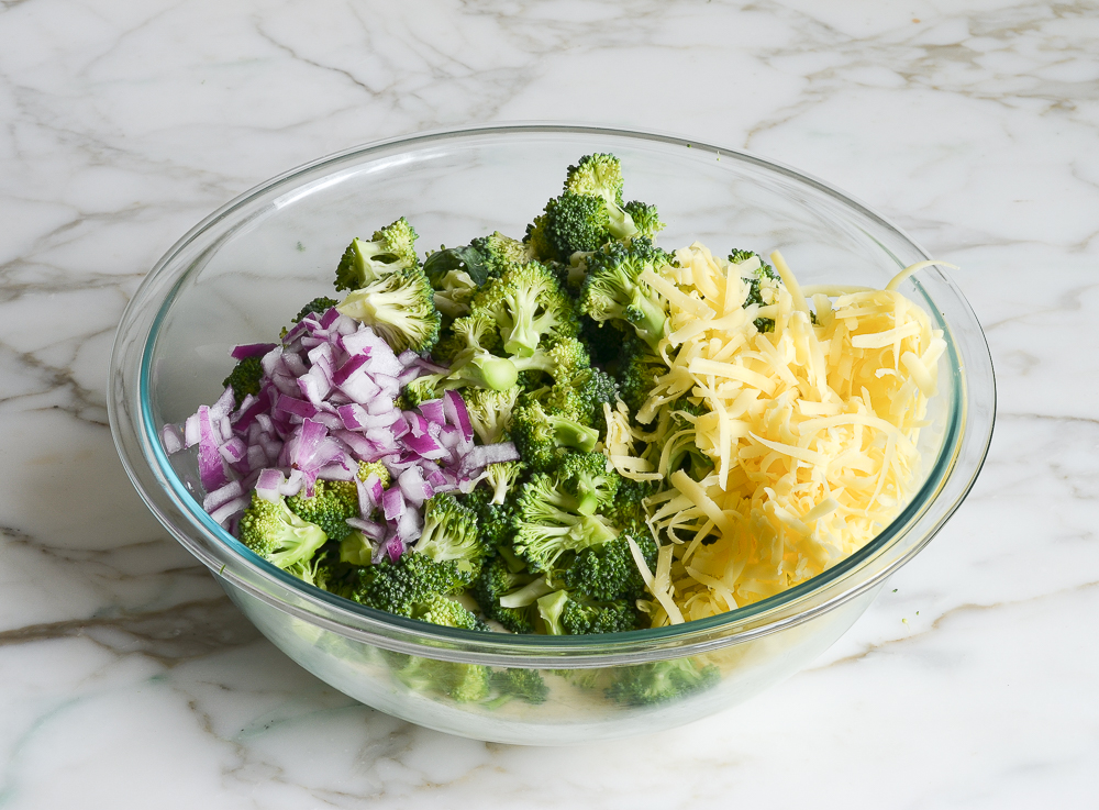 adding the broccoli, Cheddar and red onions to the dressing