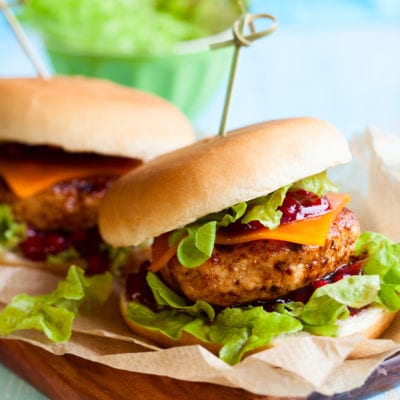 Two turkey burgers on a cutting board.