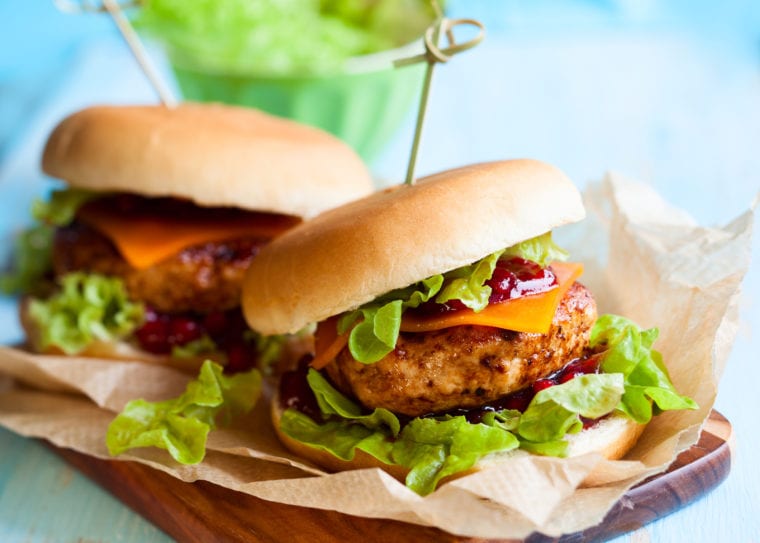 Two turkey burgers on a cutting board.