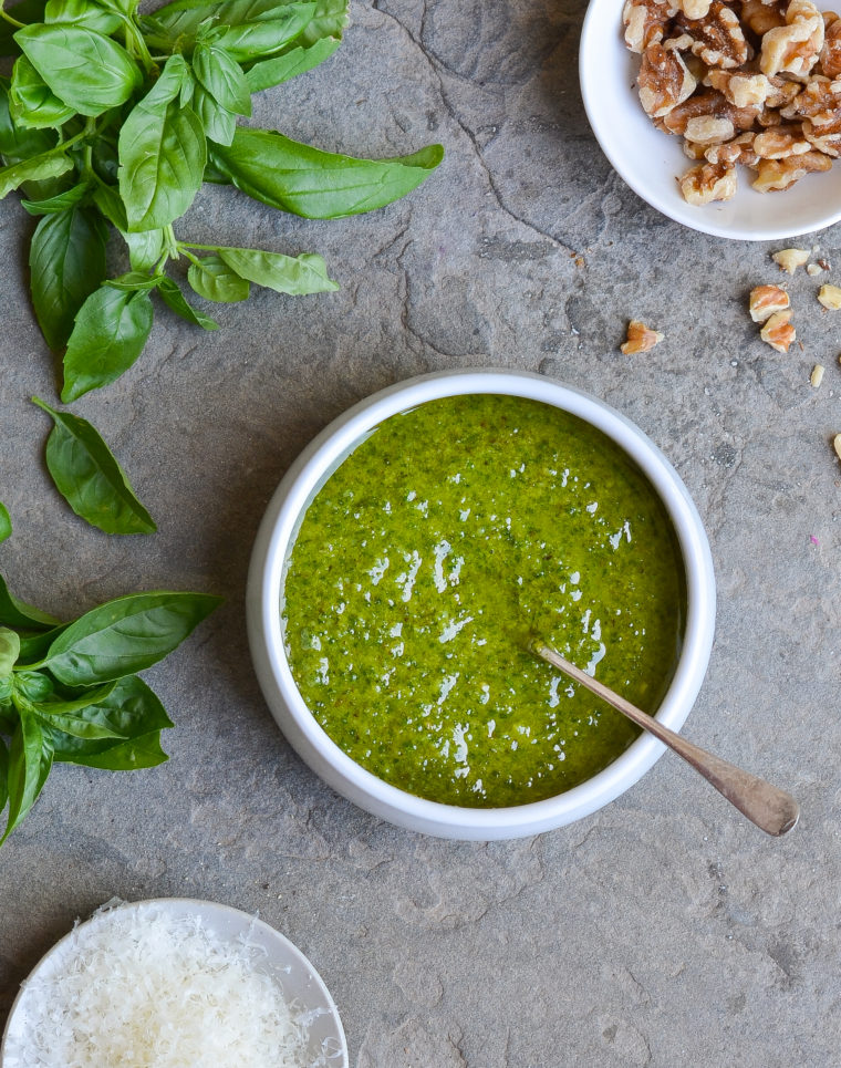 Spoon in a bowl of pesto sauce.