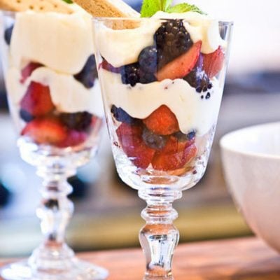 two lemon berry parfaits on wooden board.