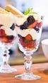 two lemon berry parfaits on wooden board.