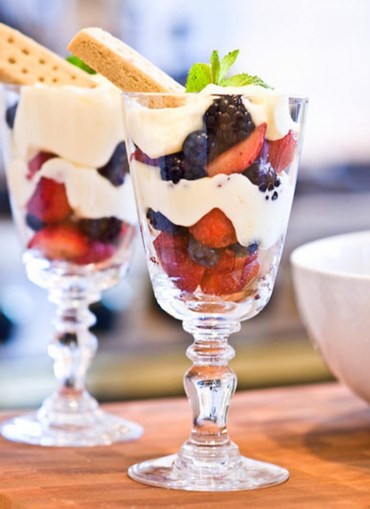 two lemon berry parfaits on wooden board.