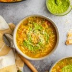 bowls of vegetable soup with spoon and linen napkin