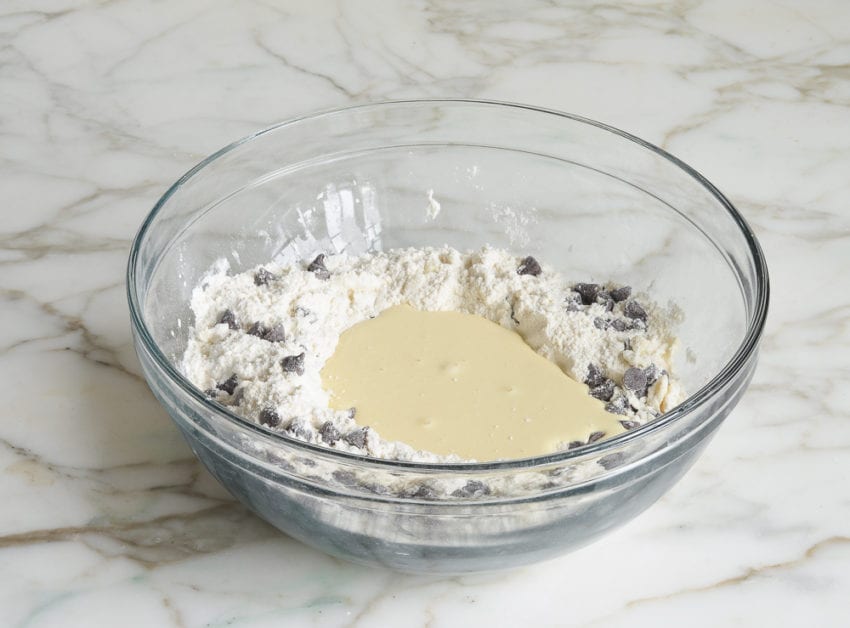 adding liquid ingredients to dry ingredients making chocolate chip scones