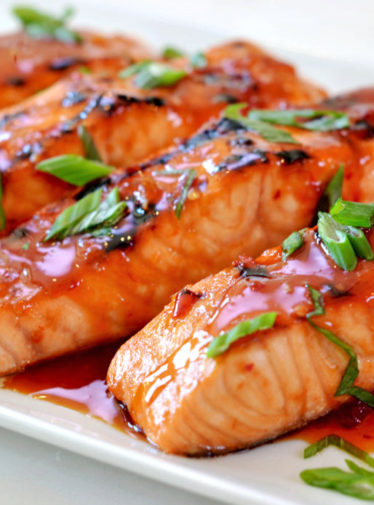 Broiled salmon with Thai sweet chili glaze on a plate.