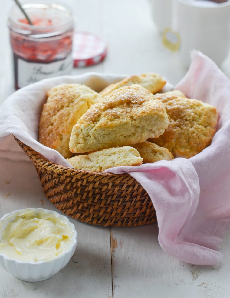 basket of scones with butter and jam.