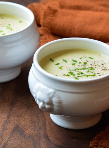 Two white crocks of potato leek soup.