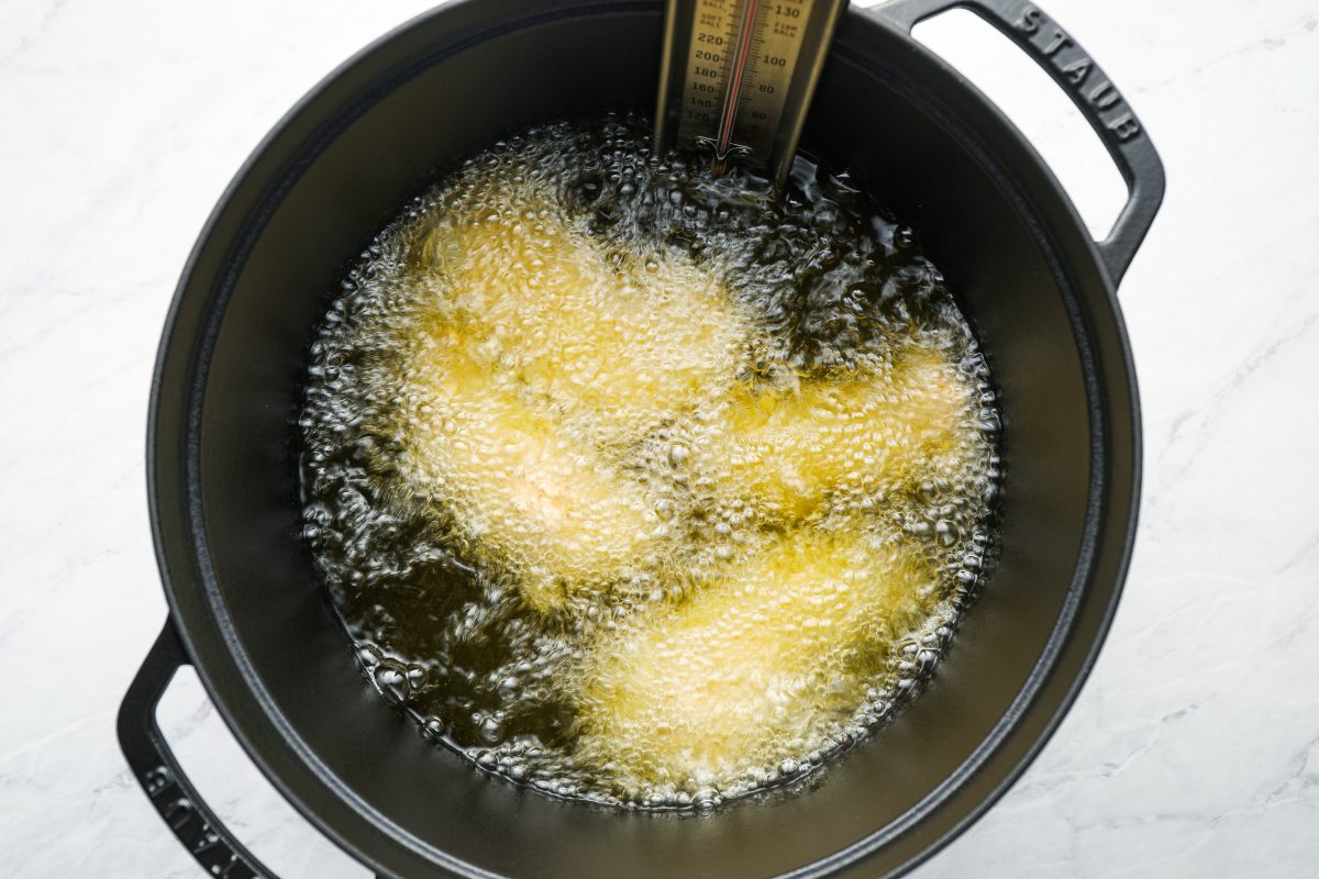 Chicken tenders frying in oil.