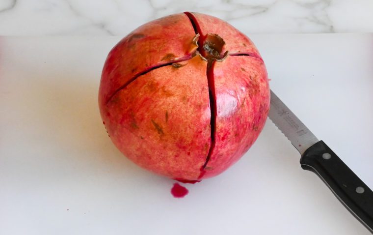 cutting a cross into the pomegranate