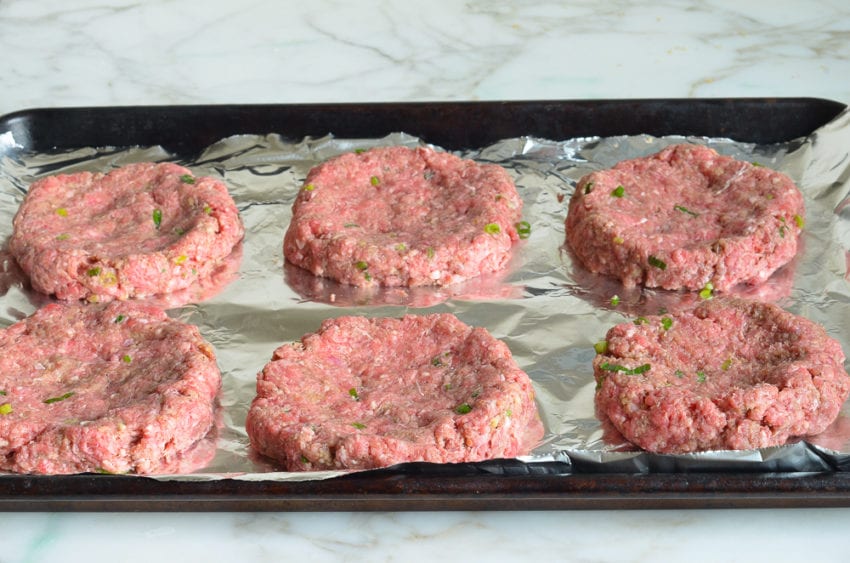 burgers ready to cook on baking sheet