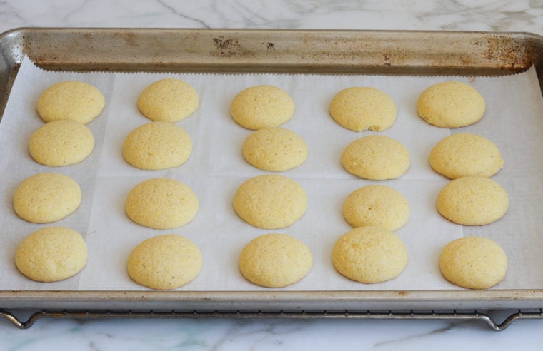 Italian cornmeal cookies on a lined baking sheet.