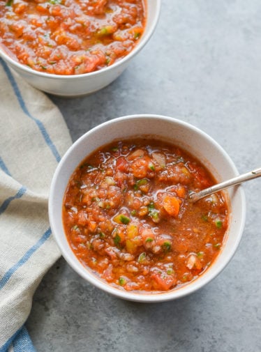 Spoon in a bowl of roasted garlic gazpacho.