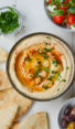 Bowl of hummus topped with whole chickpeas.
