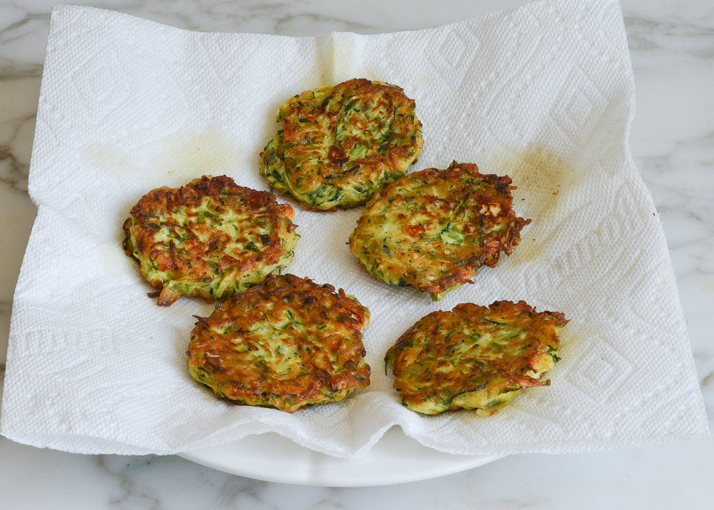 draining zucchini fritters on paper towels