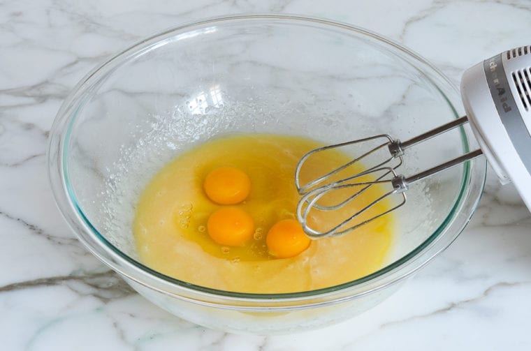 Eggs in a bowl with butter mixture.