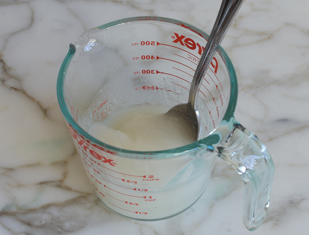 Spoon in a measuring cup with a sugar mixture.