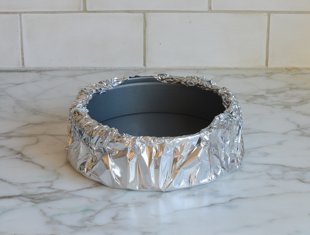 Springform pan wrapped in aluminum foil.