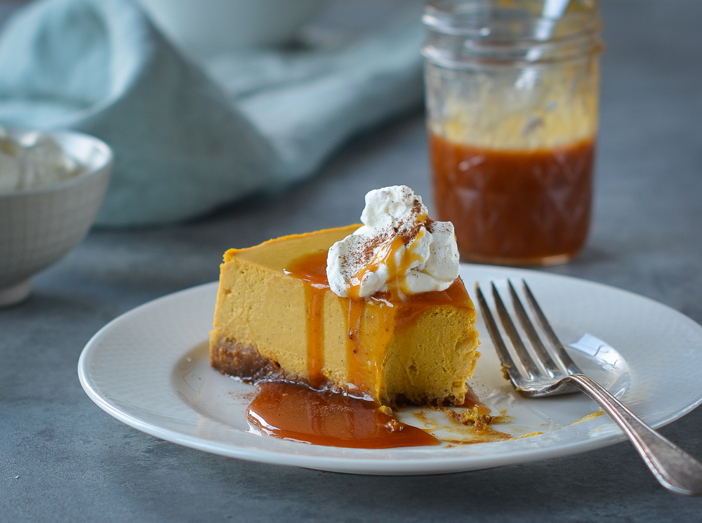 Slice of pumpkin cheesecake topped with caramel.